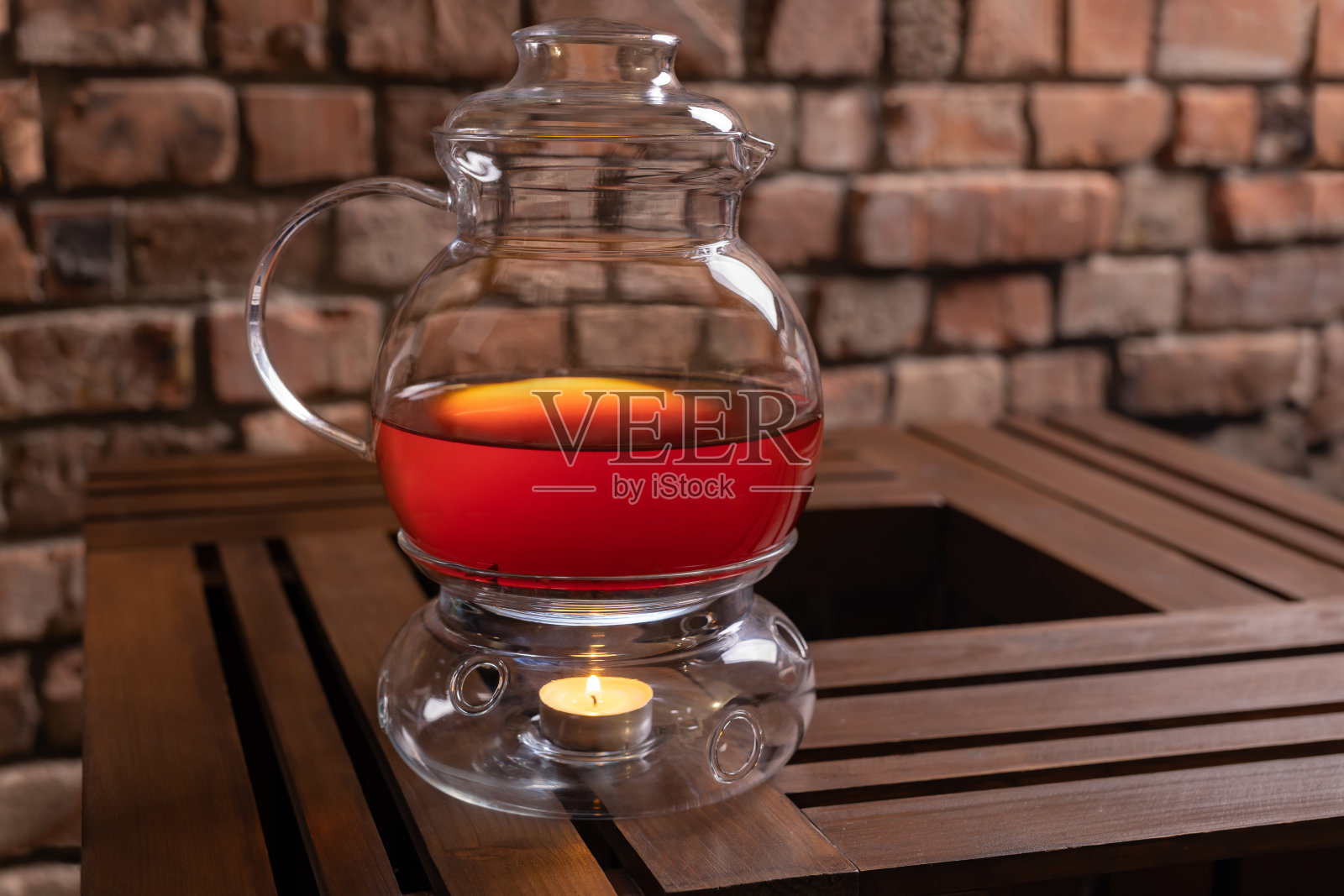 茶壶放在木桌上，有一个蜡烛加热器照片摄影图片