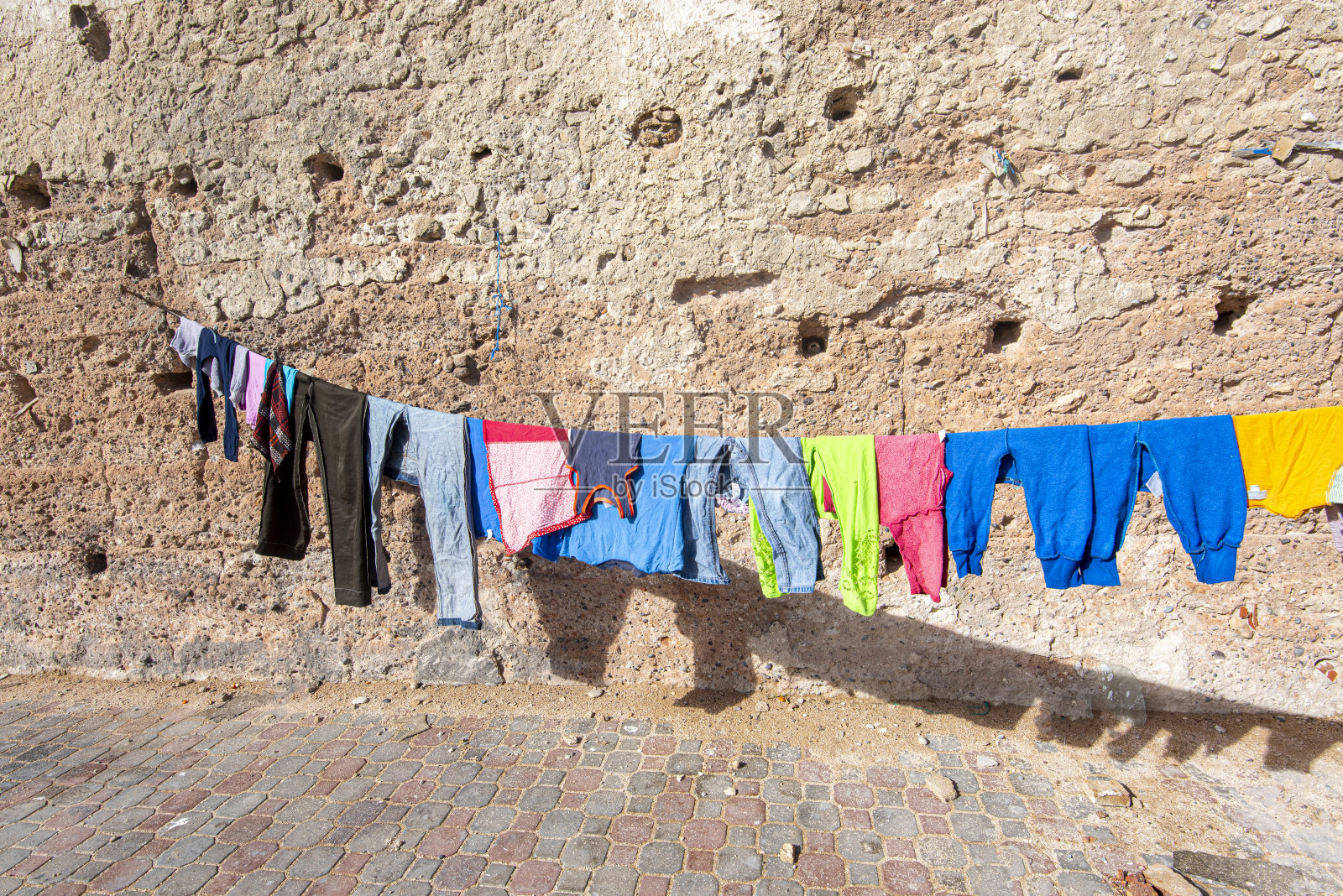 在摩洛哥街头，用绳子或晾衣绳晒干的衣服照片摄影图片