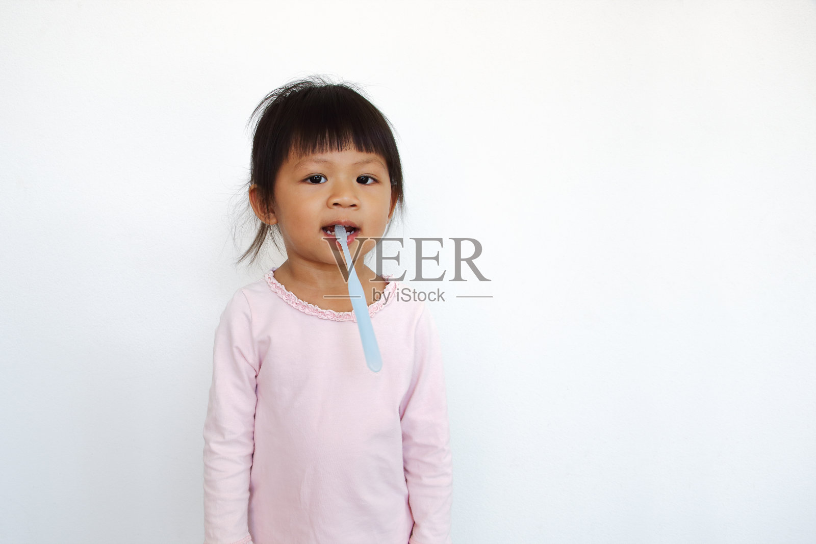 有趣的亚洲小孩咬牙刷照片摄影图片
