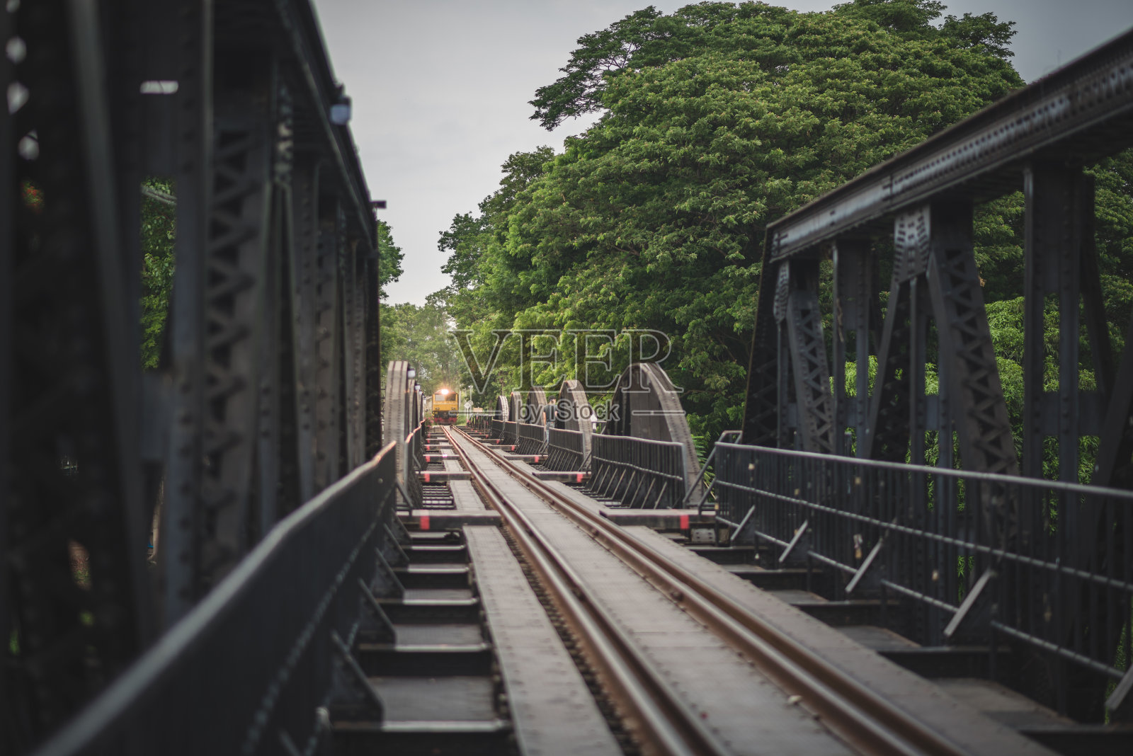 在泰国北碧府，这列火车正驶过横跨桂河的铁路桥。照片摄影图片
