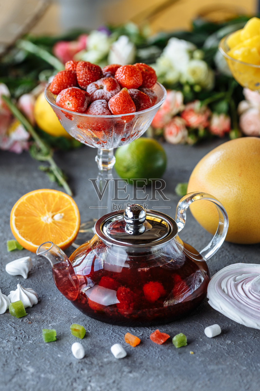 玻璃茶壶与水果覆盆子茶和薄荷在一个蓝色的背景与水果和装饰品照片摄影图片