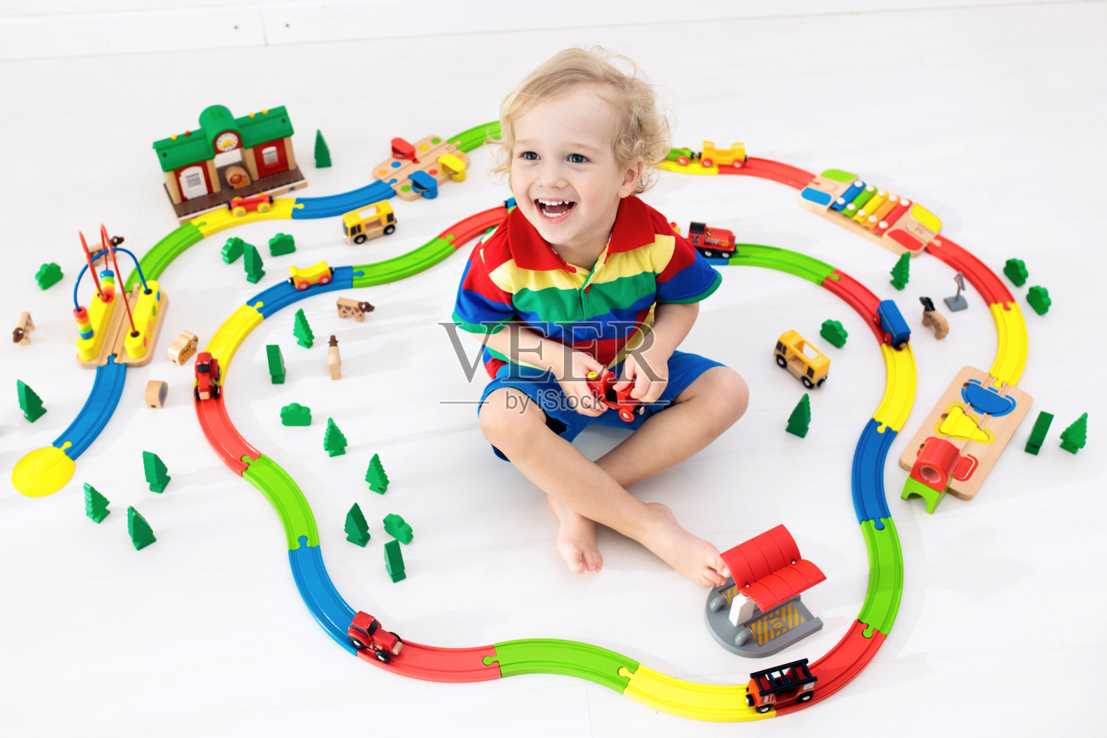 有玩具火车的孩子。儿童木制铁路。照片摄影图片