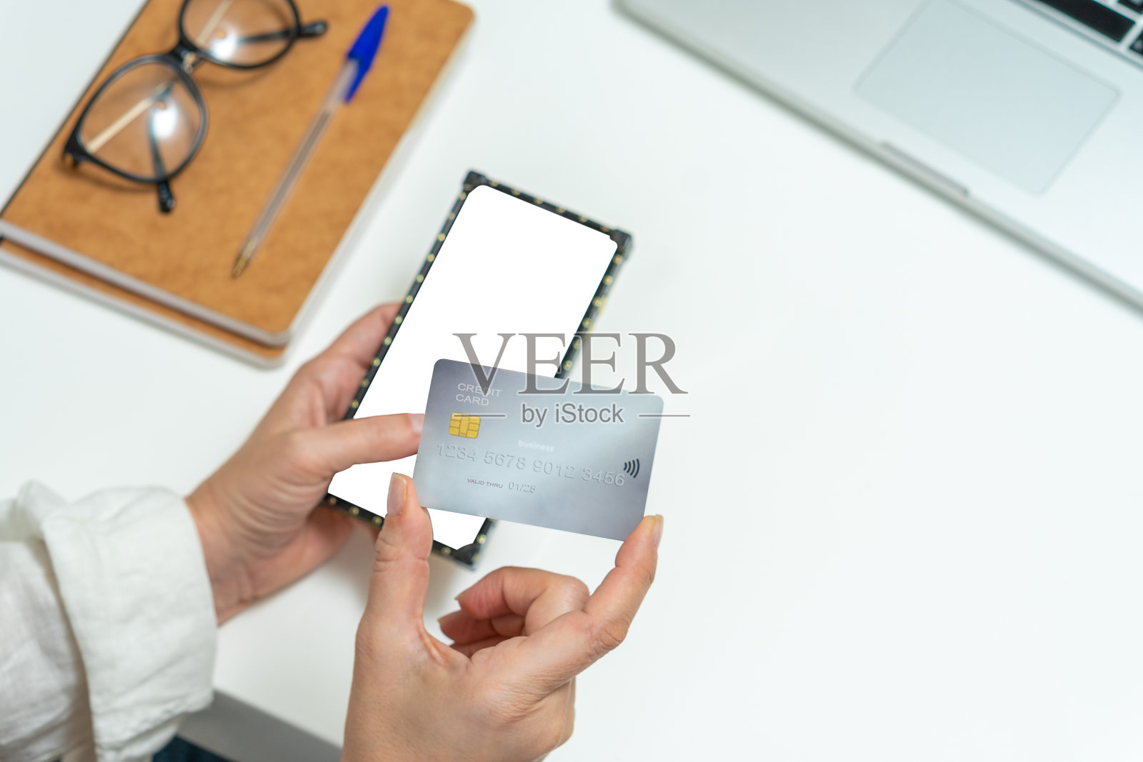 女人手里拿着信用卡和空白的手机屏幕照片摄影图片