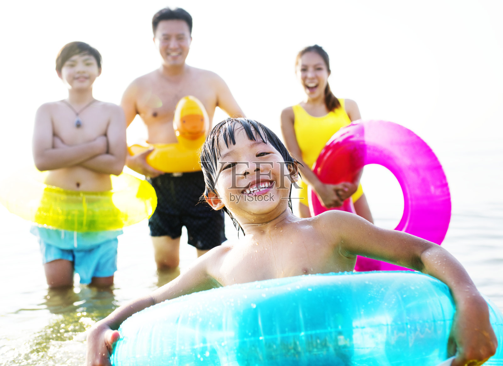 一个快乐的孩子在浮管里游泳照片摄影图片