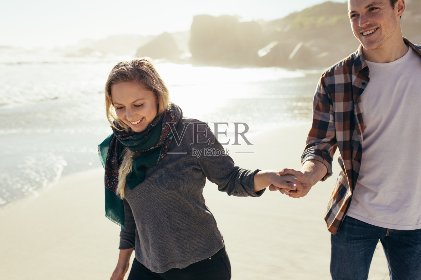 一对情侣手牵着手在海滩上散步照片摄影图片