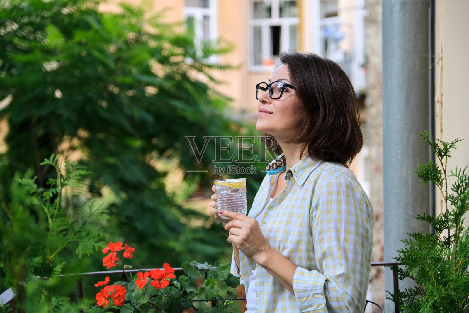 成熟的女人喝柠檬水。天然抗氧化剂，减肥饮料照片摄影图片