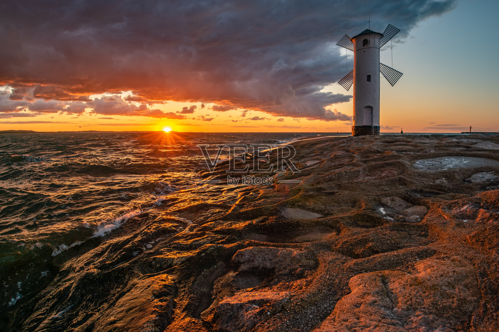 在波兰Swinoujscie的一个风车形状的灯塔在戏剧性的日落照片摄影图片