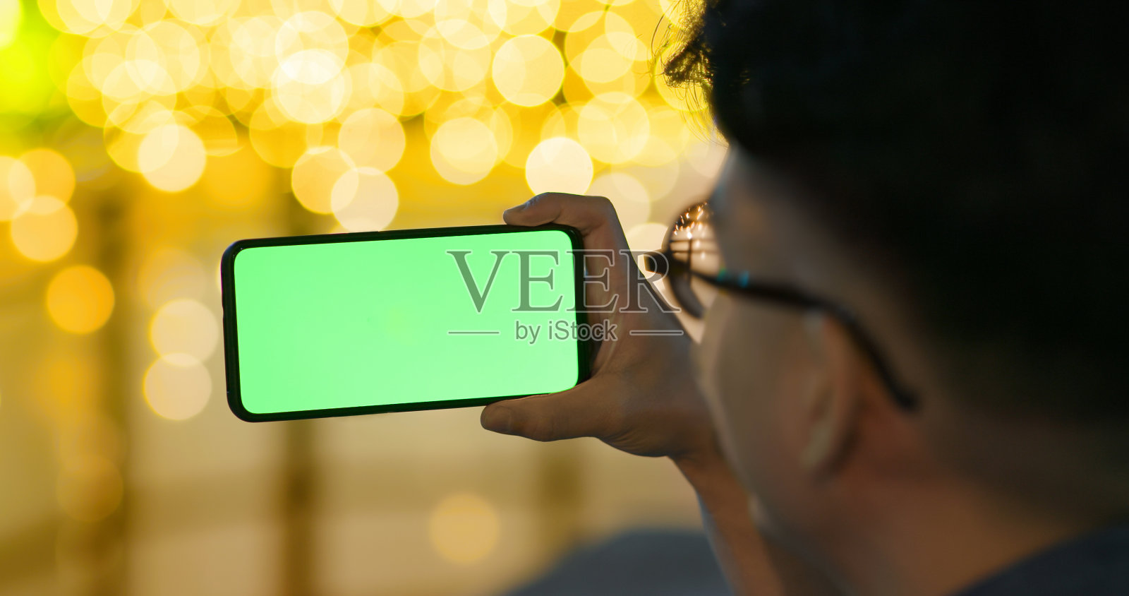 男子使用绿色屏幕的电话照片摄影图片