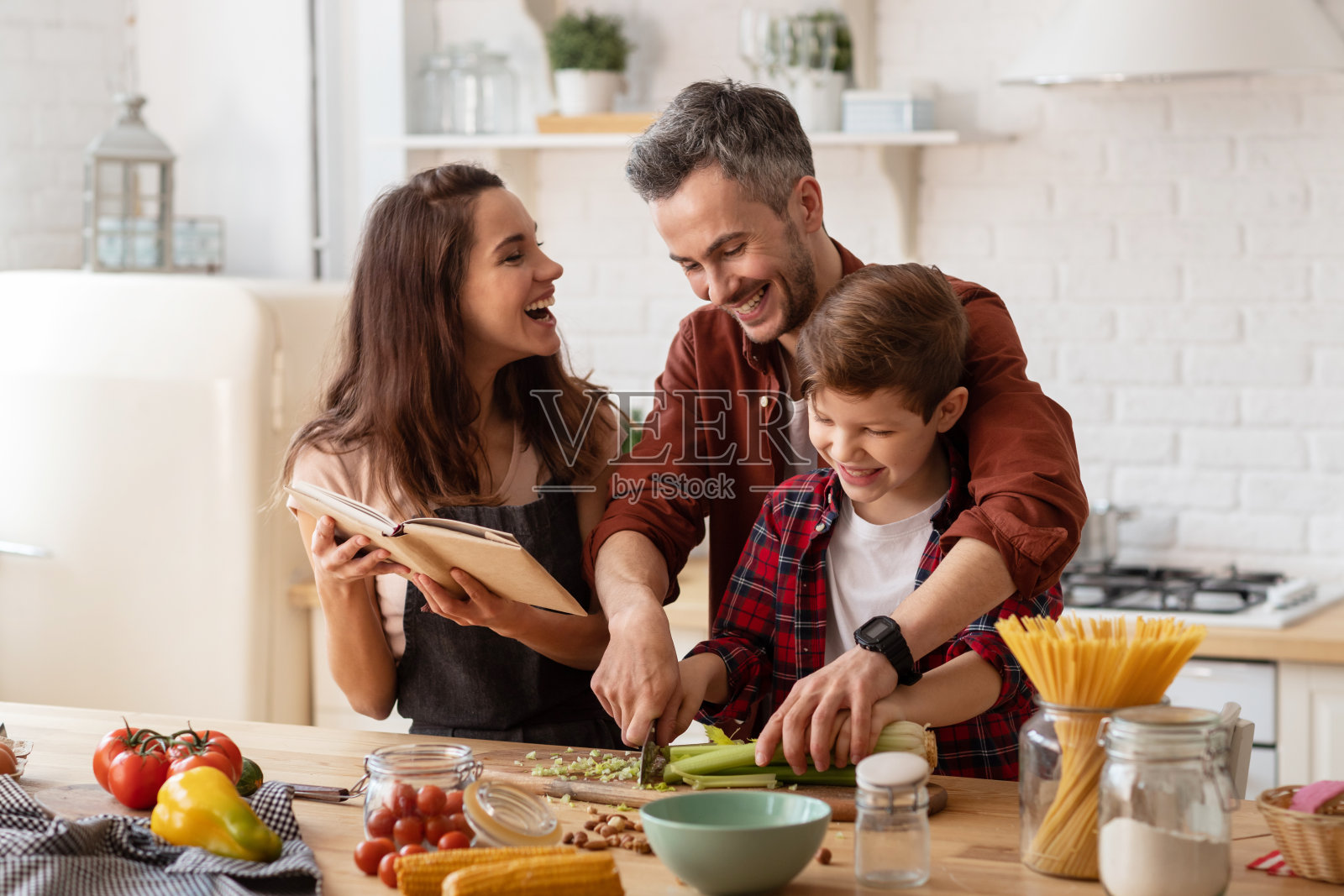 快乐的家庭大笑，在厨房做饭照片摄影图片