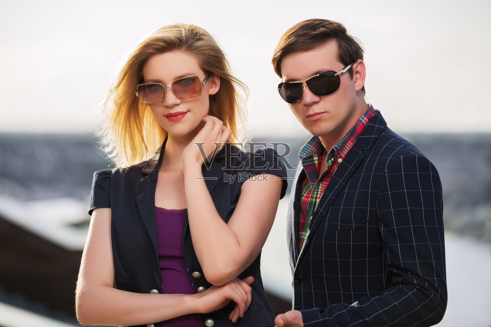 一对年轻的时尚夫妇戴着太阳镜在户外散步照片摄影图片