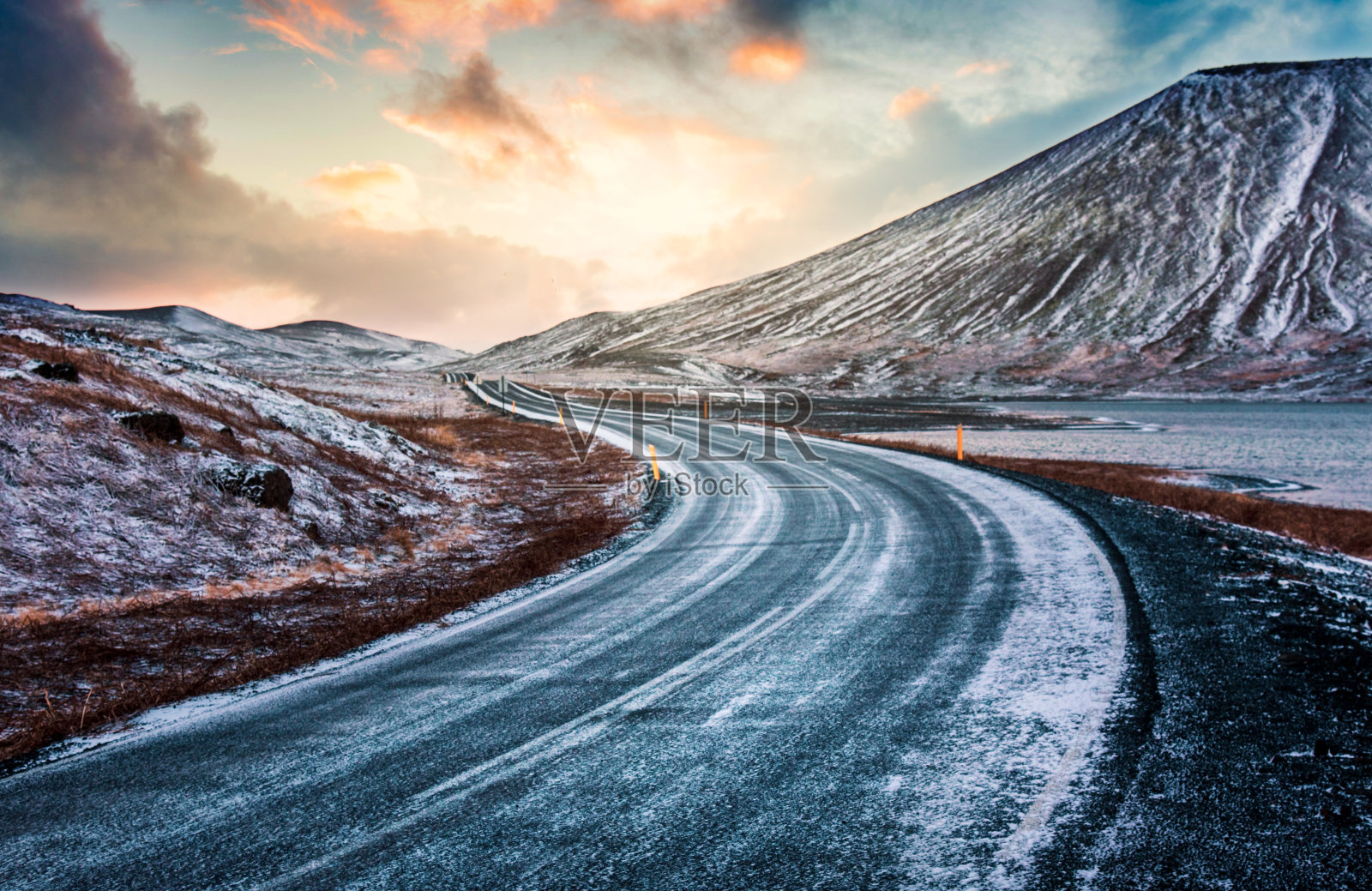 冬天的一天，冰岛的风景优美的道路被雪覆盖着照片摄影图片