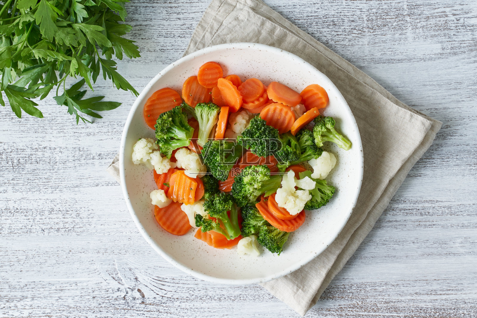 混合煮熟的蔬菜。花椰菜、胡萝卜、花椰菜。蒸熟的蔬菜照片摄影图片