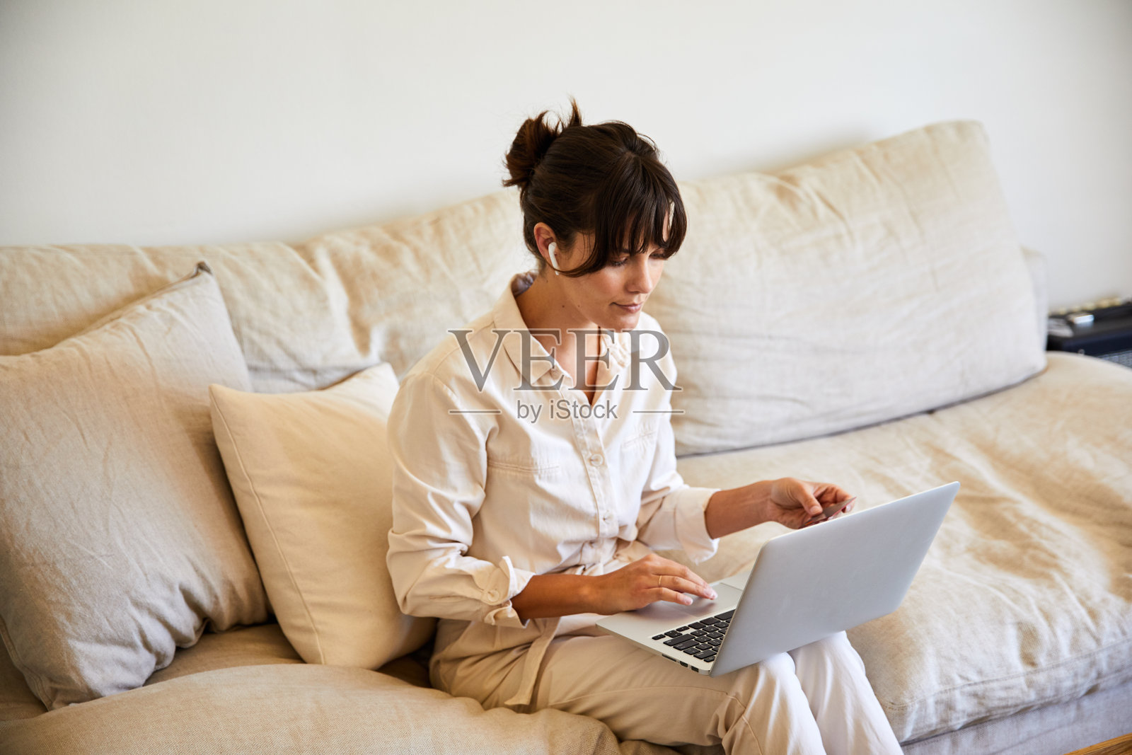 年轻女子坐在沙发上用笔记本电脑工作照片摄影图片