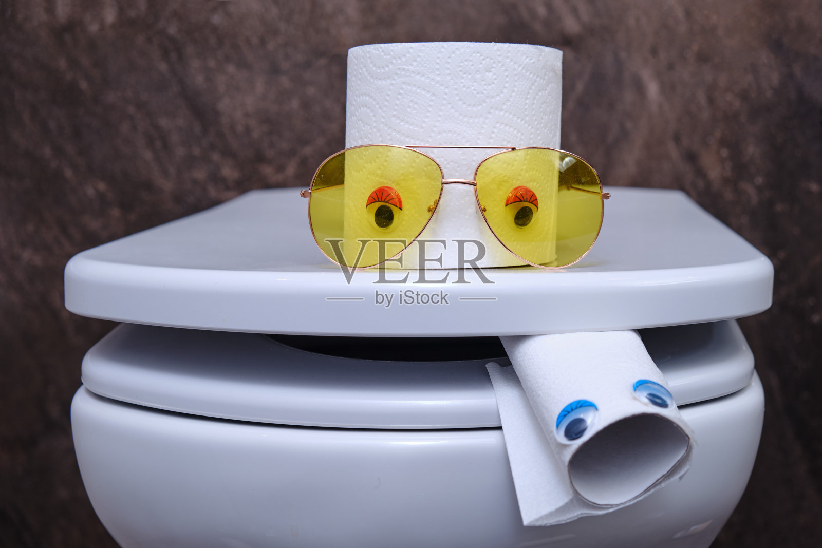 幽默用完了厕纸。一个有眼睛和舌头的有趣厕所的概念。照片摄影图片
