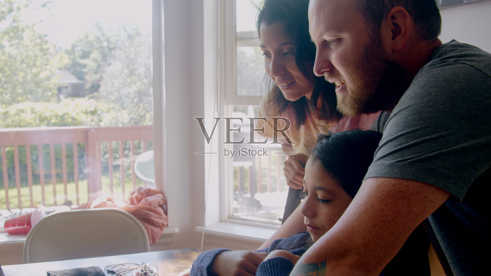 一个年轻的混血家庭挤在一起，在一台笔记本电脑前与远方的爱人视频聊天照片摄影图片