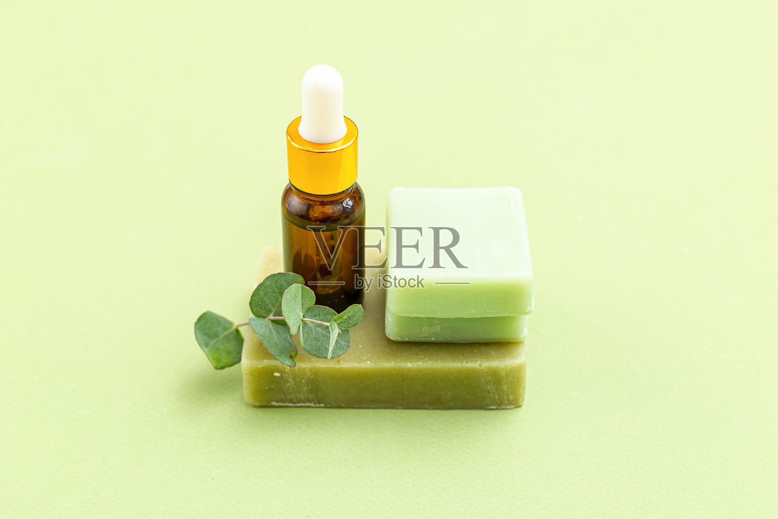 绿色背景上的肥皂、桉树和血清。皮肤护理。极简主义照片摄影图片