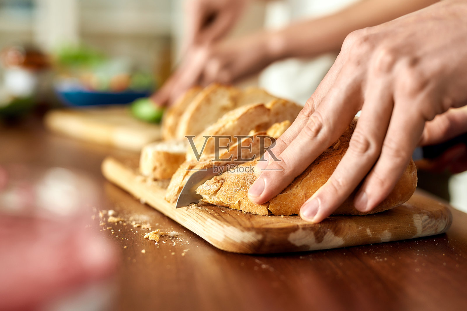 男性的手在木板上切美味的自制面包的特写。素食主义，健康饮食理念。照片摄影图片