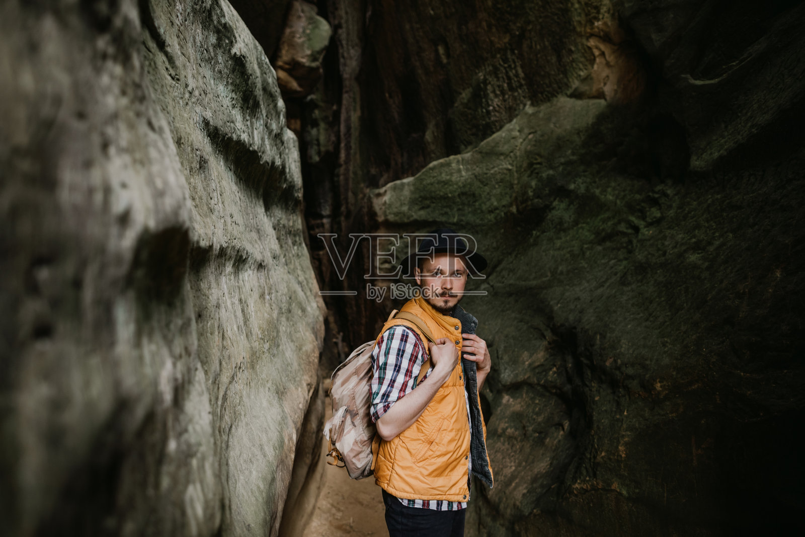 那个旅行者站在一个山洞里。在山里远足照片摄影图片