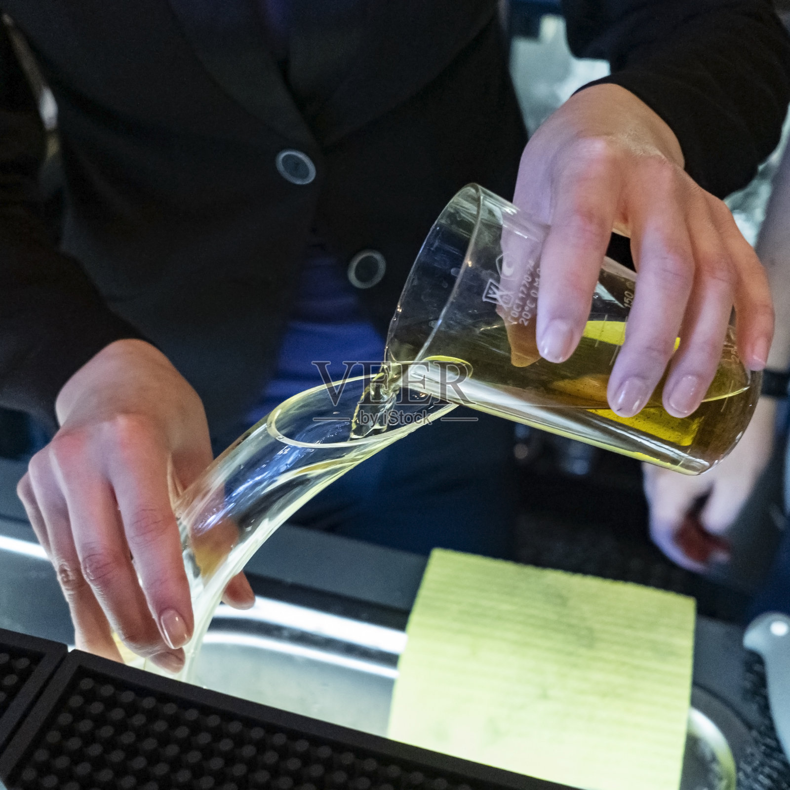 在葡萄酒商店，侍酒师用手从醒酒器倒酒。葡萄酒的概念。照片摄影图片