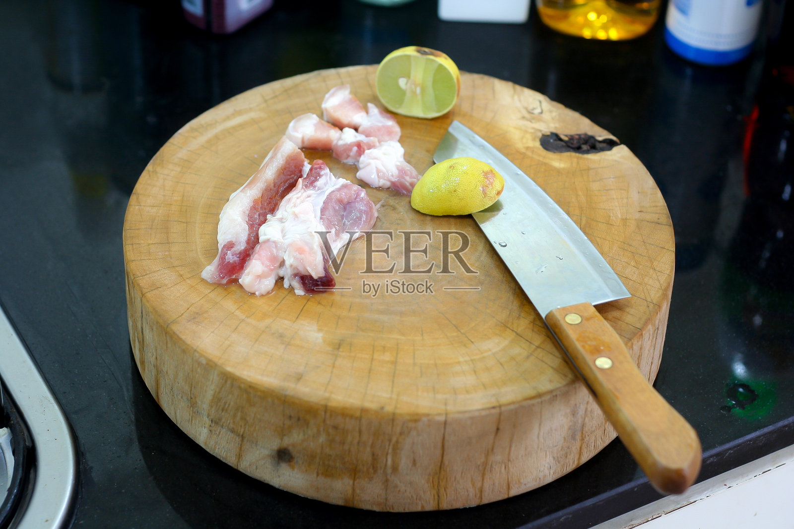 在砧板上切猪肉。切木板上的刀和生猪肉照片摄影图片
