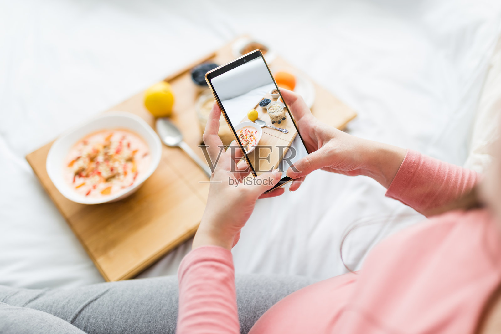 孕妇用手机拍健康餐。照片摄影图片