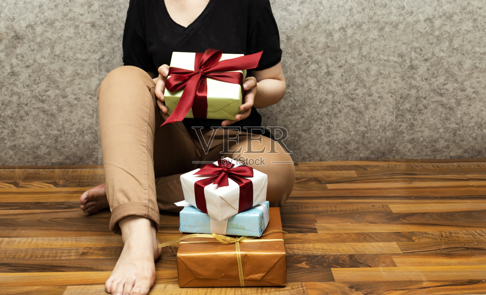 特写女人坐在地板上，拿着礼物，圣诞节的概念照片摄影图片