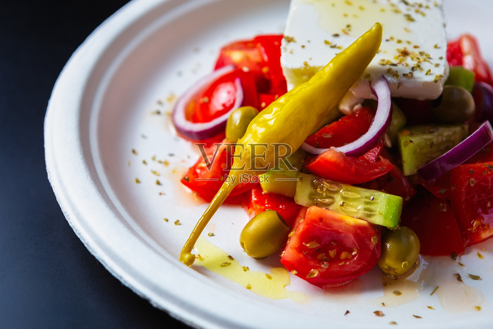 在地中海咖啡馆，新鲜的希腊沙拉和蔬菜被装在白色可回收的纸盘里照片摄影图片