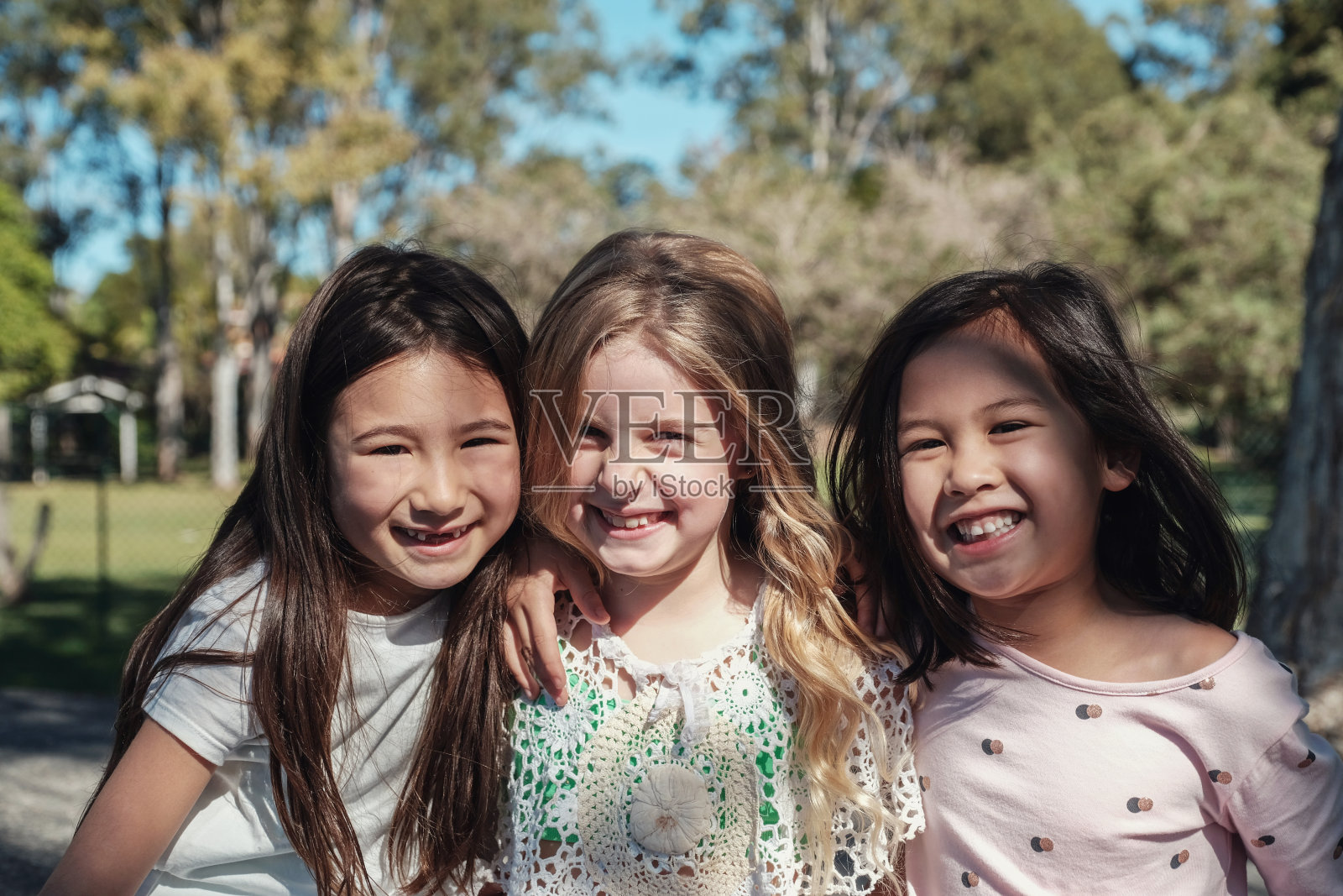 快乐和健康的混合民族小女孩拥抱和微笑在公园，最好的朋友和友谊的概念照片摄影图片