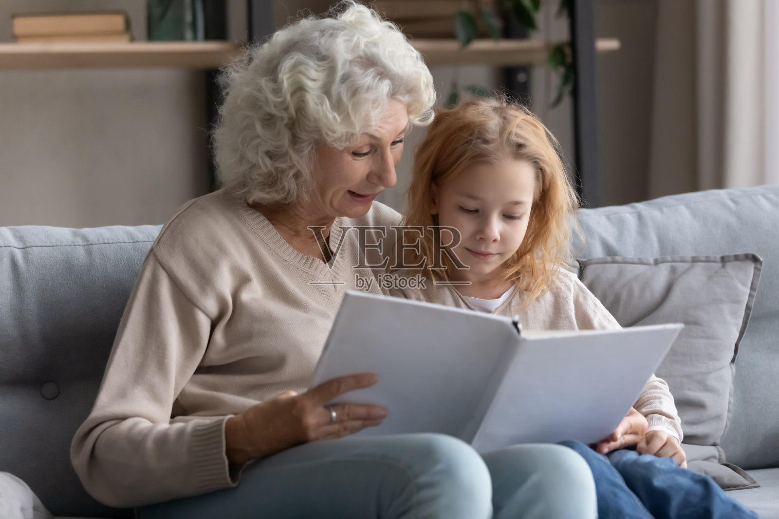 照顾老祖母和小孙女一起读书照片摄影图片