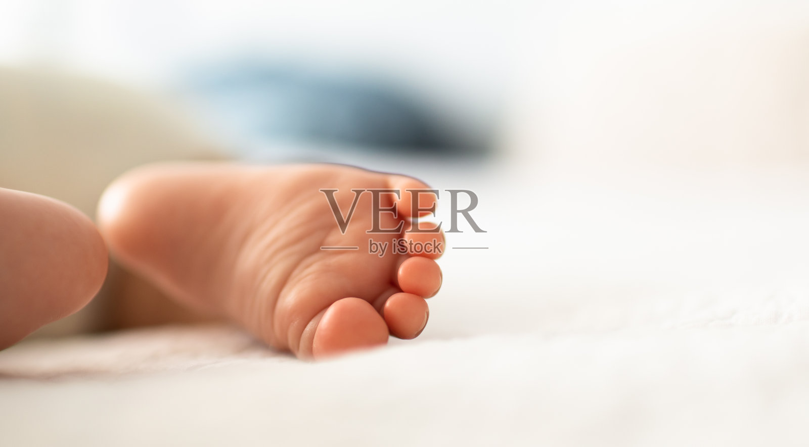 新生儿的小脚丫躺在床上。宝宝的脚。照片摄影图片
