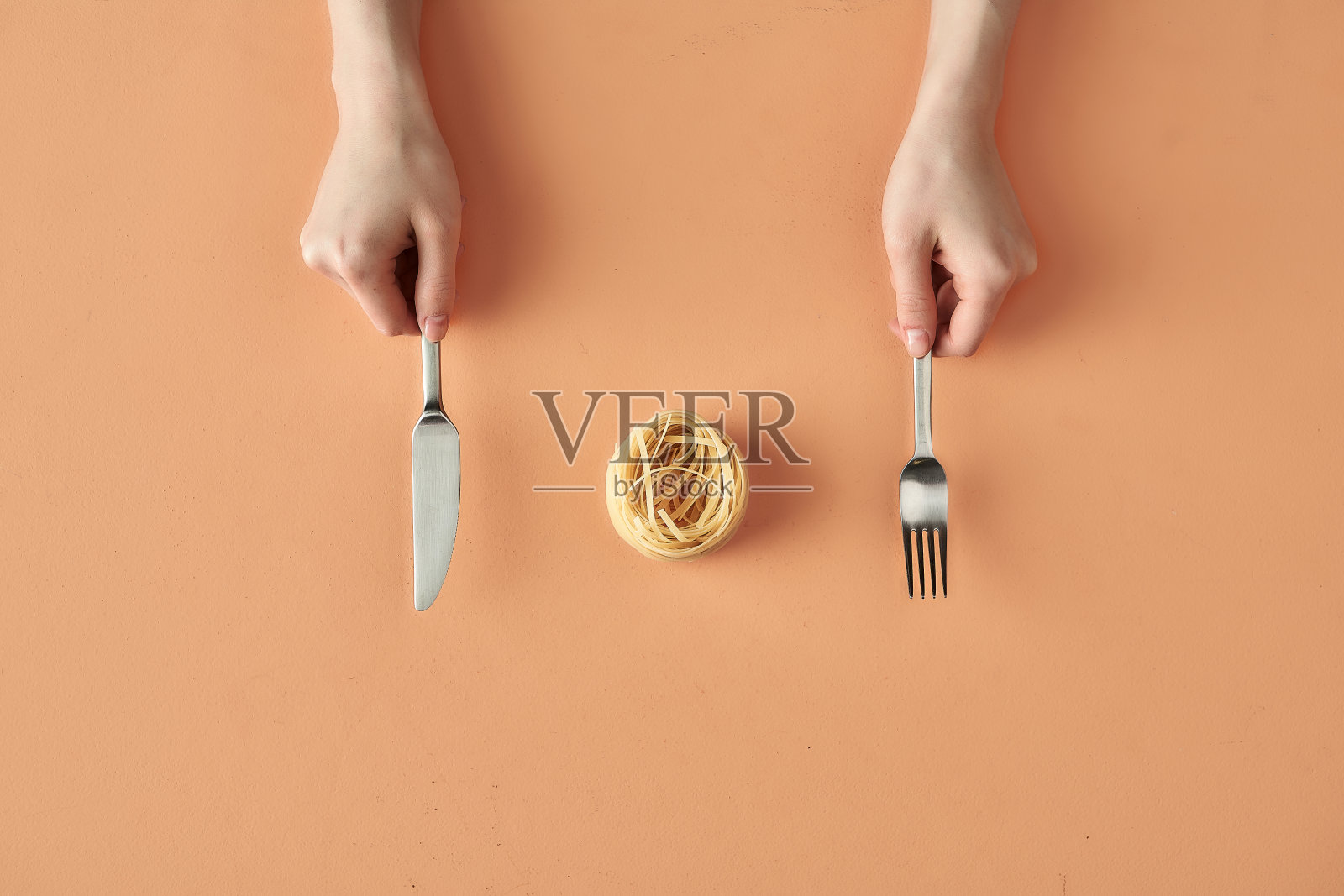 米色背景上孤立的手叉和刀，极简主义的美食博客或广告照片照片摄影图片