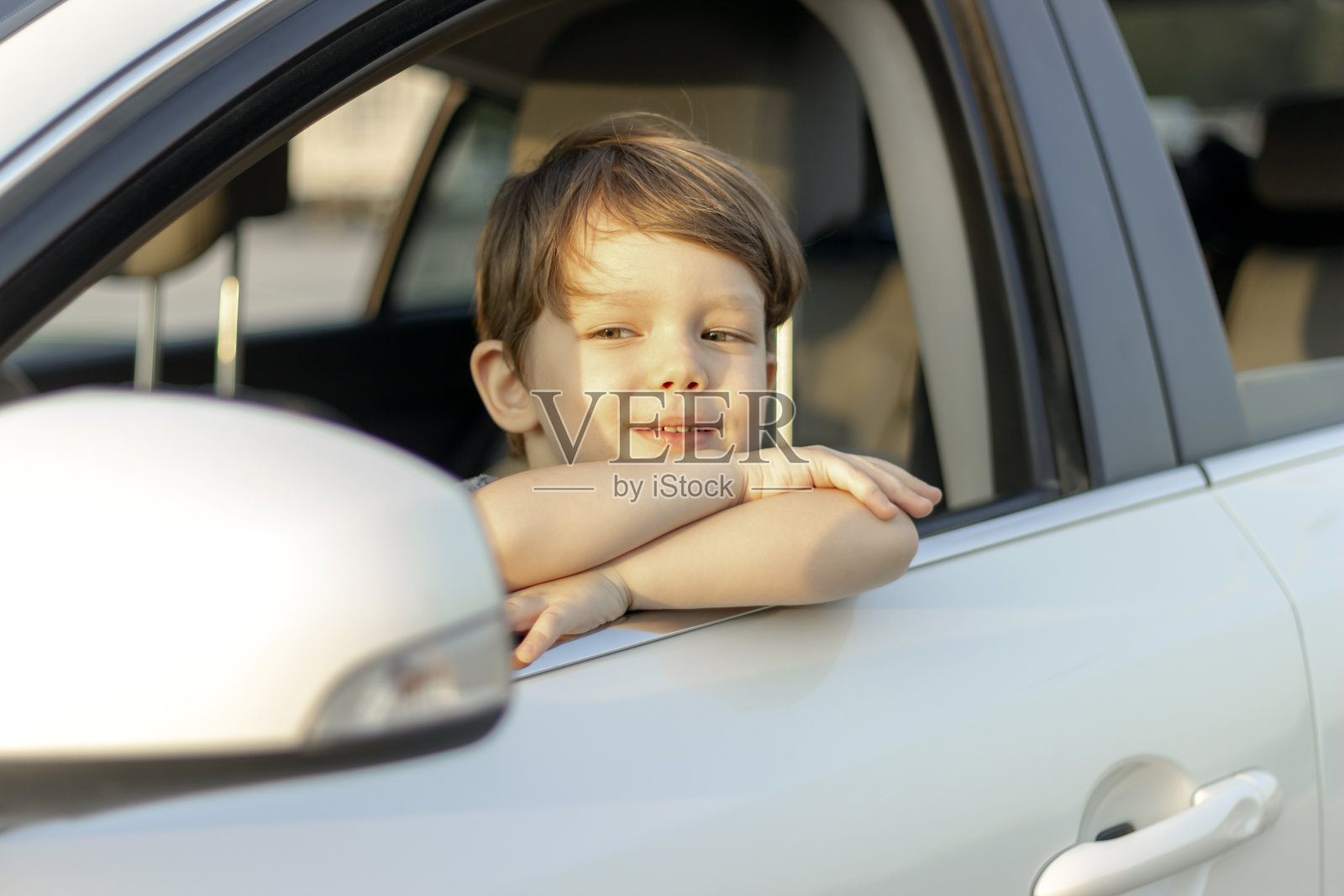 可爱的小男孩看着车外享受公路旅行照片摄影图片