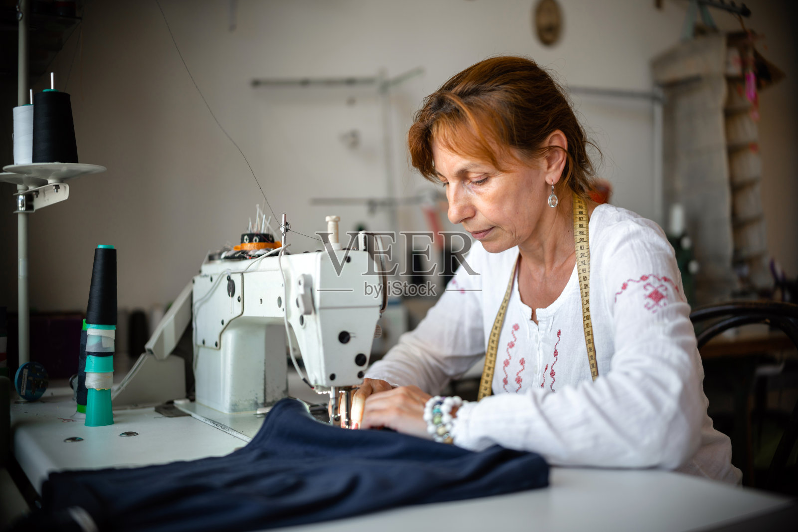一个女裁缝在她的缝纫工作室工作的肖像照片摄影图片