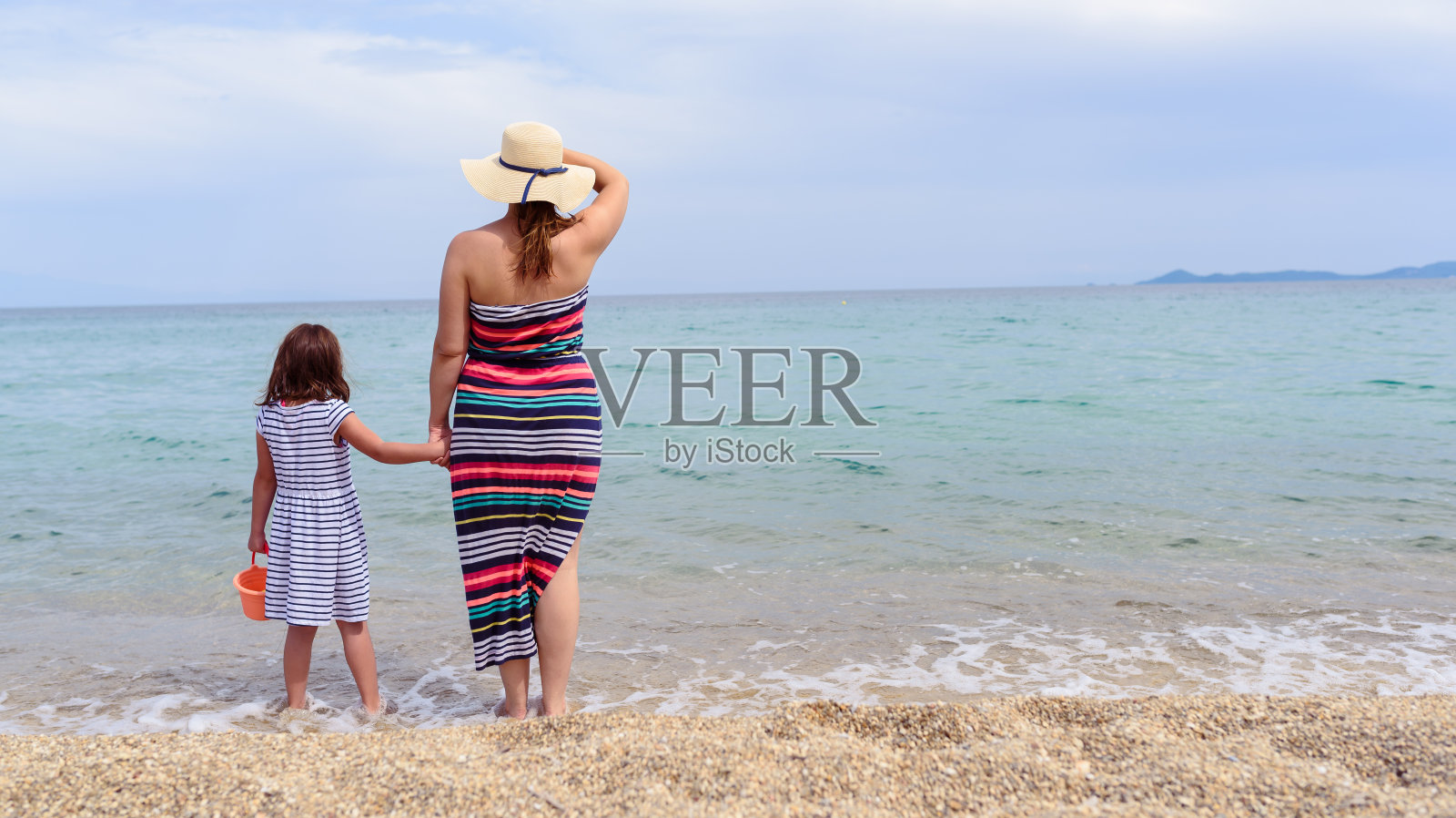 妈妈和小女儿在热带海滩上散步照片摄影图片