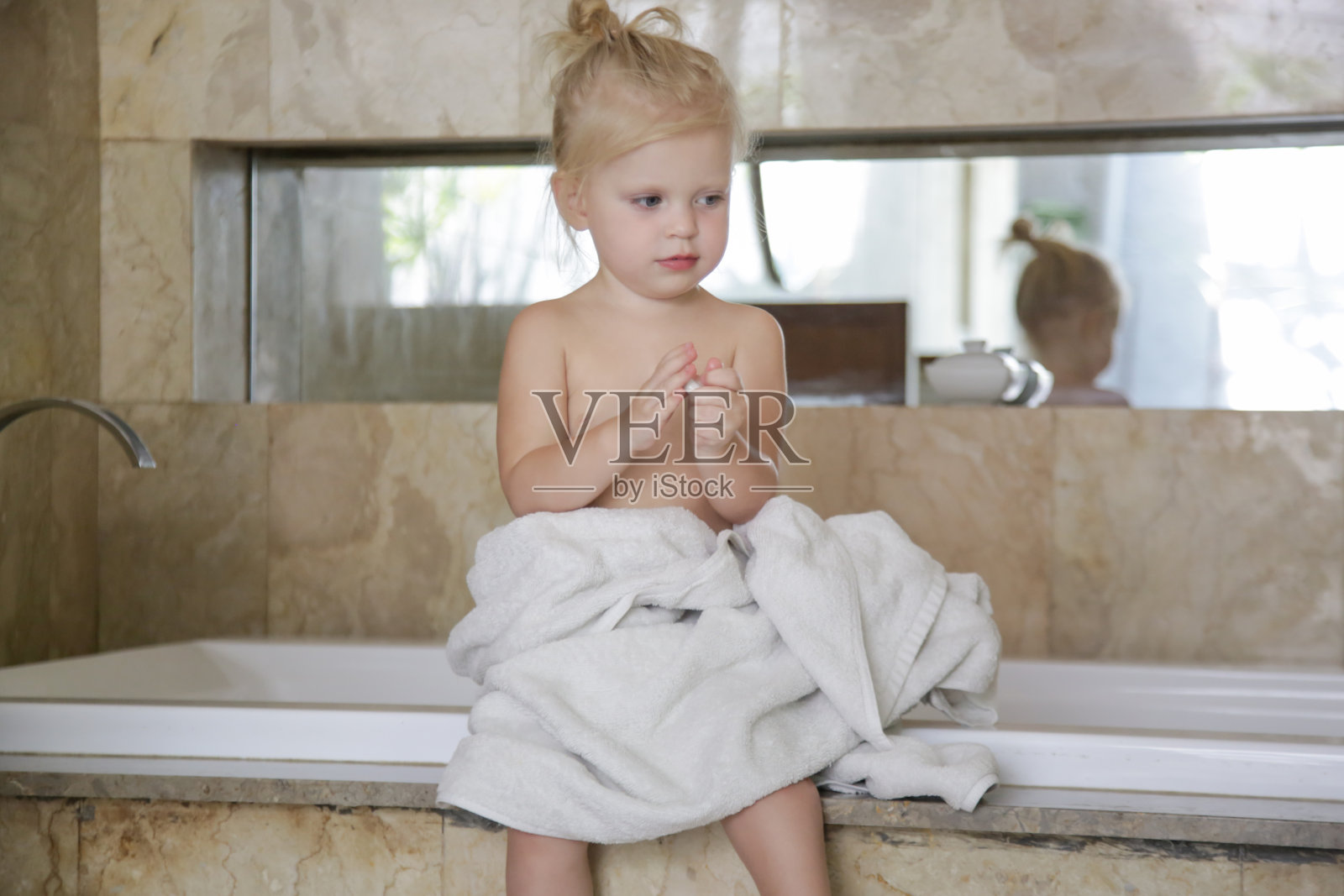 在浴室里裹着毛巾的小女孩的肖像照片摄影图片