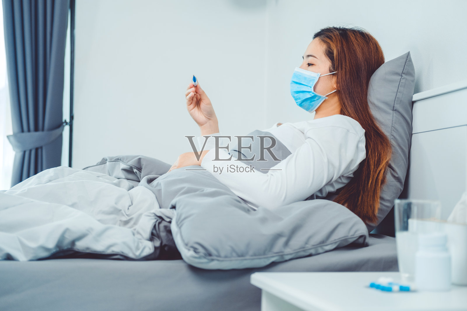 亚洲妇女流感和感冒，感到不舒服和使用温度计检查发烧。感觉不舒服的健康问题的治疗理念照片摄影图片
