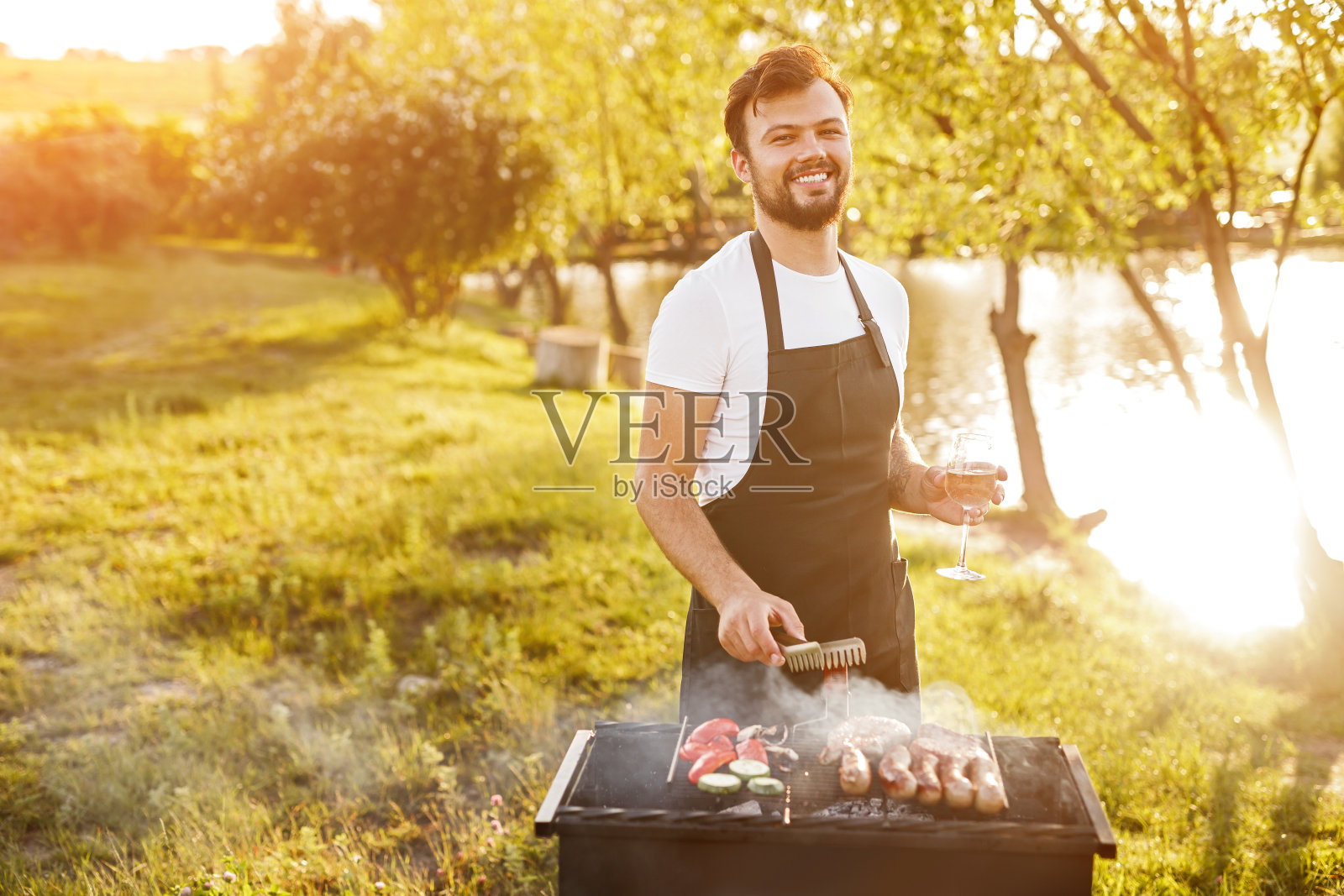 愉快的男性准备烧烤在火盆上的自然照片摄影图片