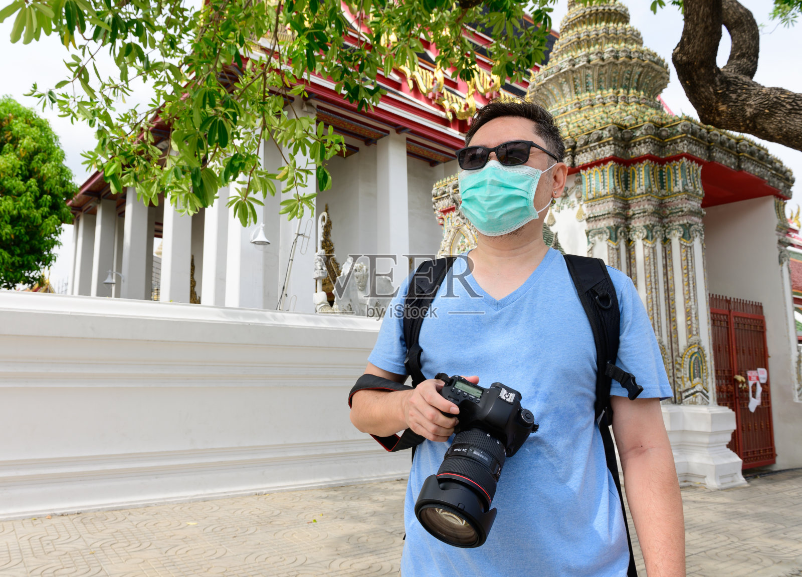 冠状病毒大流行后的生活亚洲男子在曼谷卧佛寺度假带着相机照片摄影图片