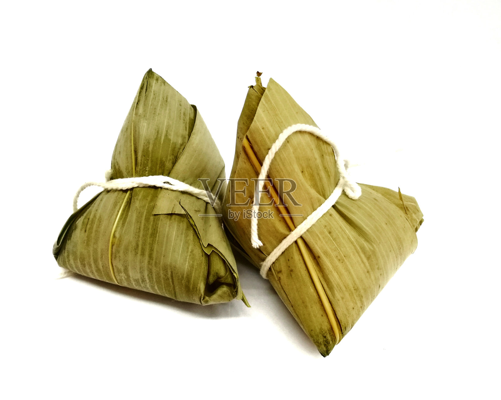 糯米饺子或粽子(金字塔形的饺子由包糯米在竹叶)孤立在白色。照片摄影图片