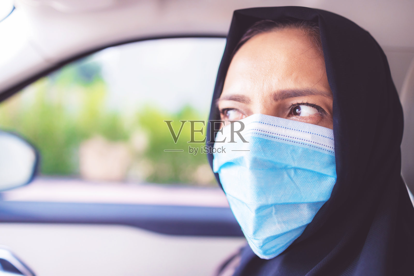 坐在汽车里的阿拉伯妇女戴着口罩- COVID-19系列照片摄影图片