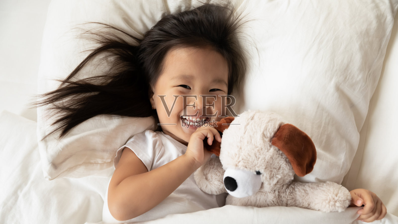 快乐的越南小女孩早上醒来。照片摄影图片