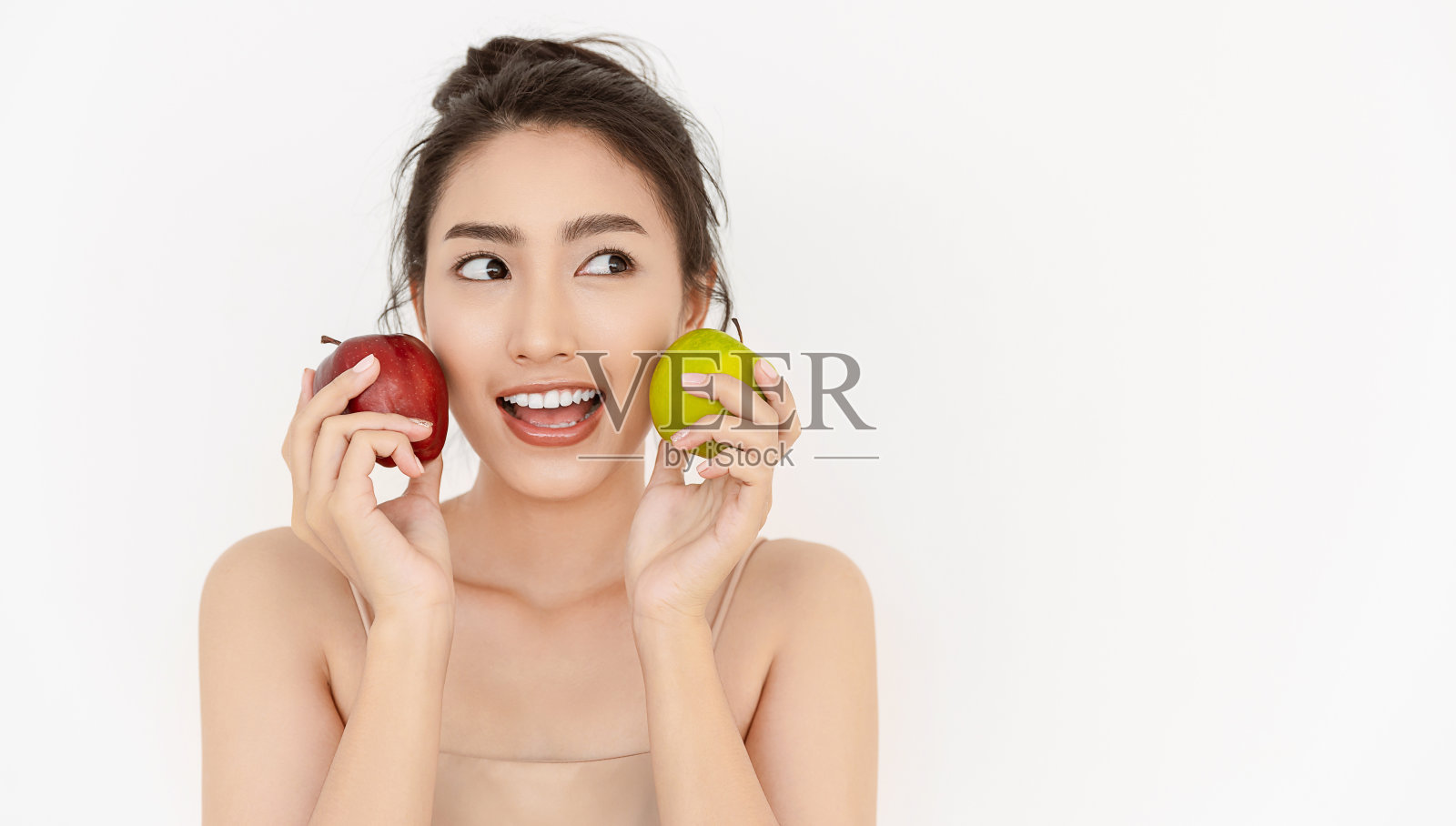 年轻美丽性感的亚洲女孩的肖像与手握绿色和红色的苹果食物，使她强壮和健康，素食女性孤立在白色的背景，保健和医疗理念照片摄影图片