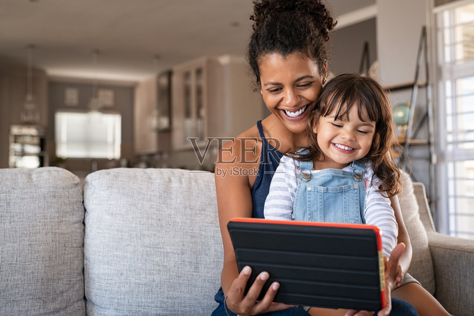 非洲微笑的母亲和快乐的女儿使用数字平板电脑照片摄影图片