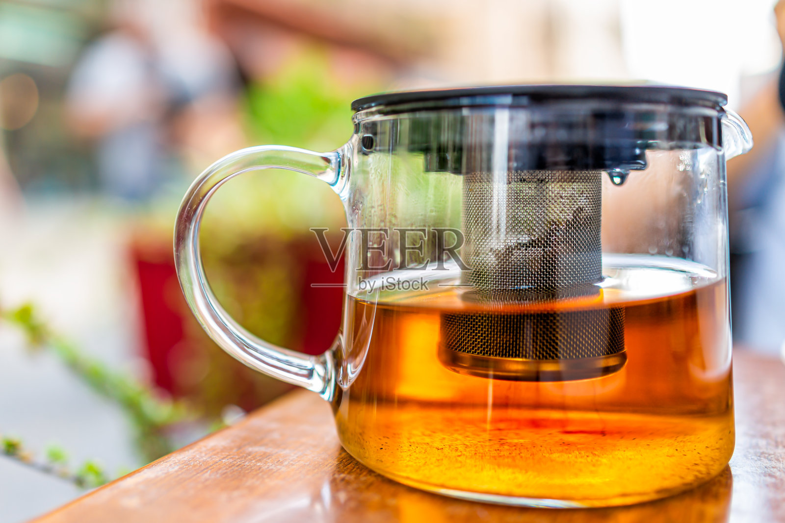 特写绿色或草药乌龙茶在玻璃茶壶与处理在早餐早午餐户外咖啡馆餐厅木桌外面照片摄影图片