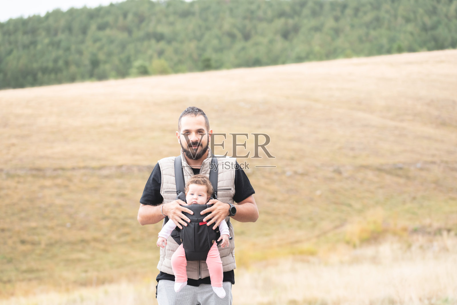 父亲带着女儿在婴儿车里徒步旅行照片摄影图片