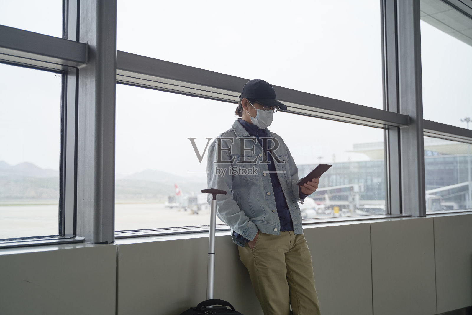 亚洲男性乘客在机场等待登机时阅读电子书照片摄影图片