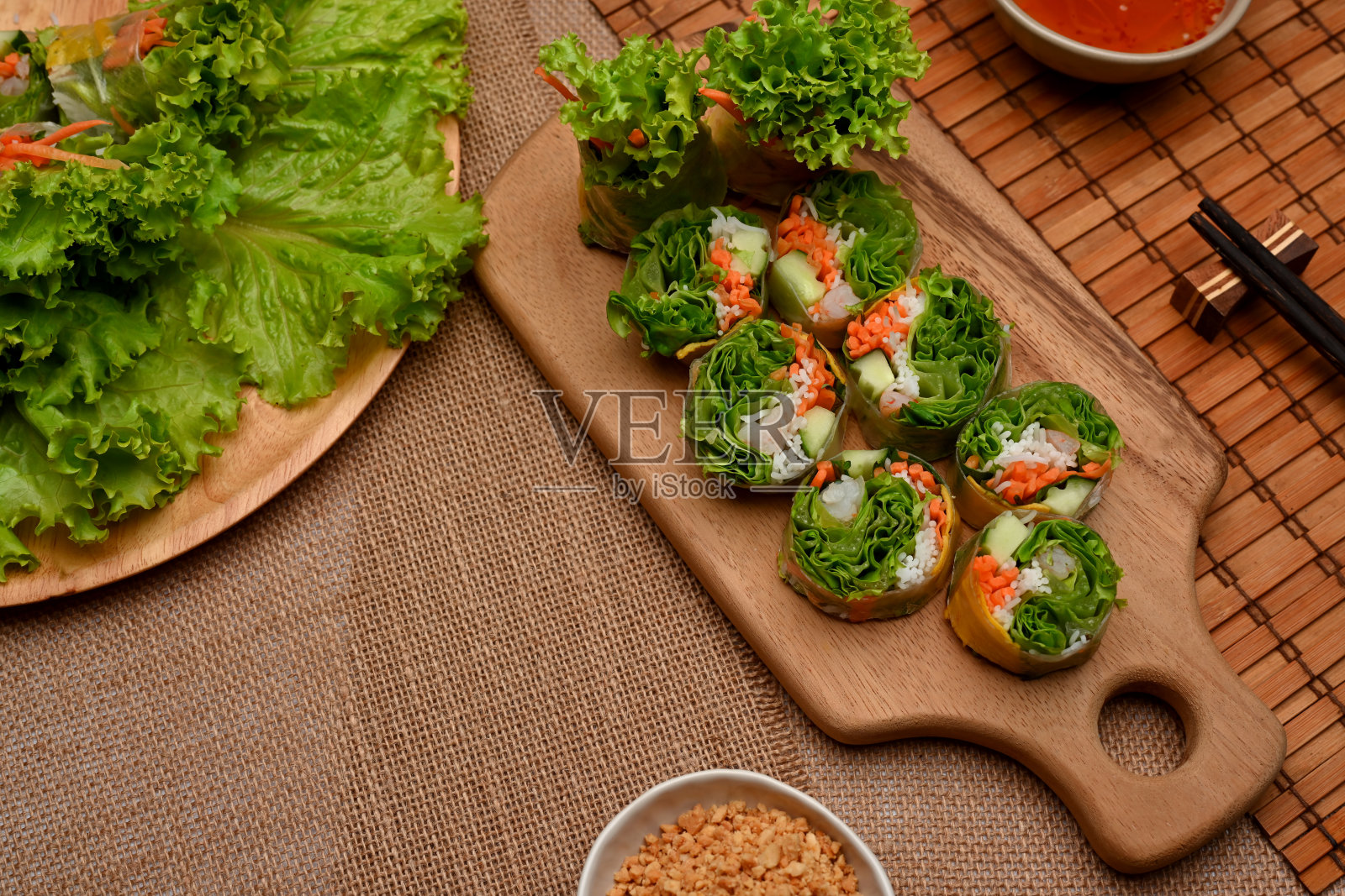 木制餐桌上的越南春卷，蘸酱和蔬菜照片摄影图片