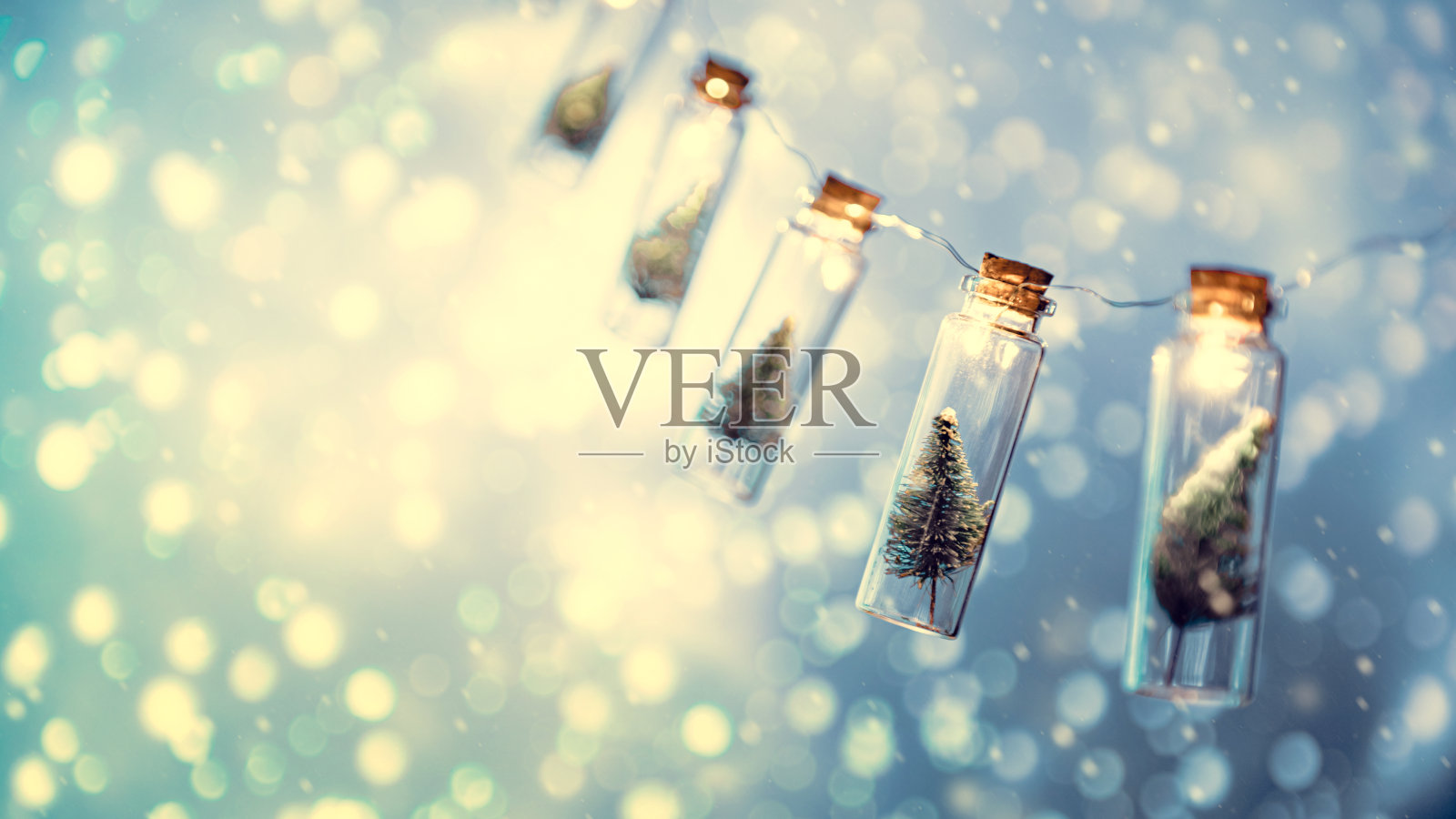 优雅的圣诞树在玻璃罐与散景灯背景，圣诞节和新年的概念。照片摄影图片