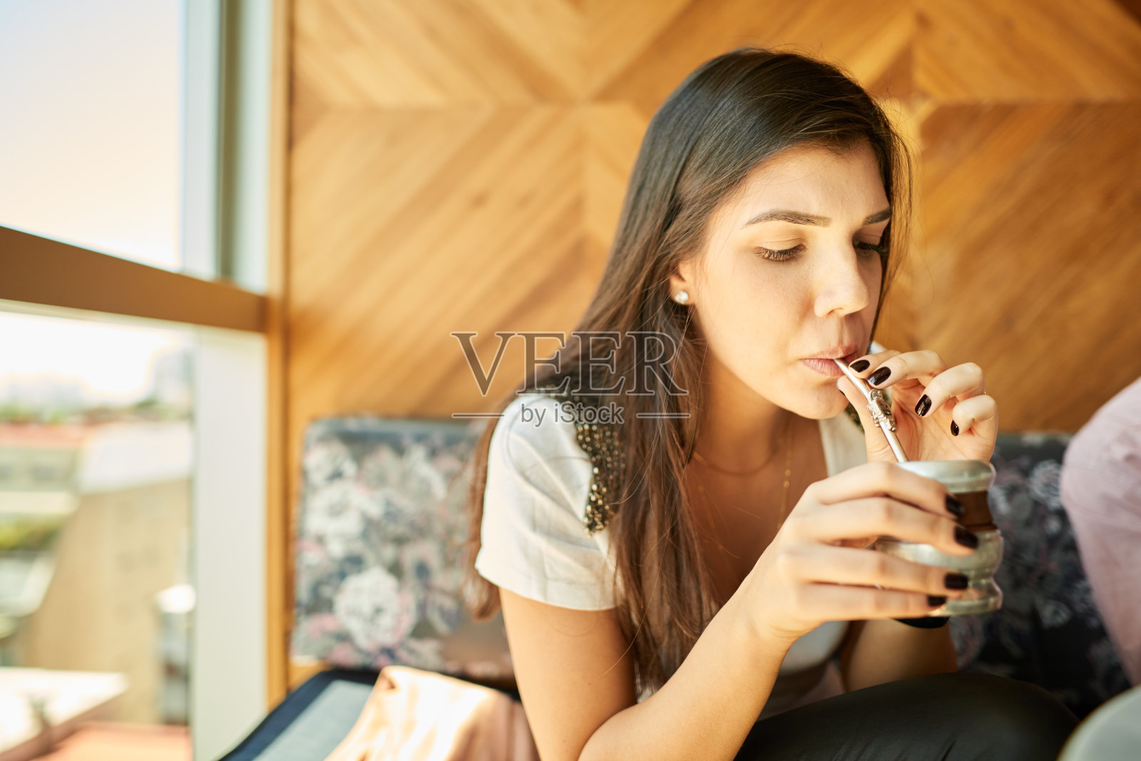 年轻女子用可重复使用的杯子和吸管喝马黛茶照片摄影图片
