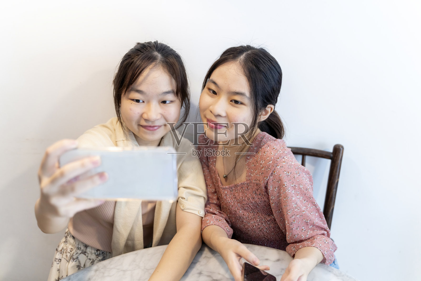 年轻的亚洲中国女孩用手机拍照照片摄影图片